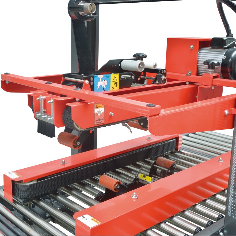 Die Frderbnder schieben den Karton durch die Fhrung und der Karton wird unten und oben verklebt