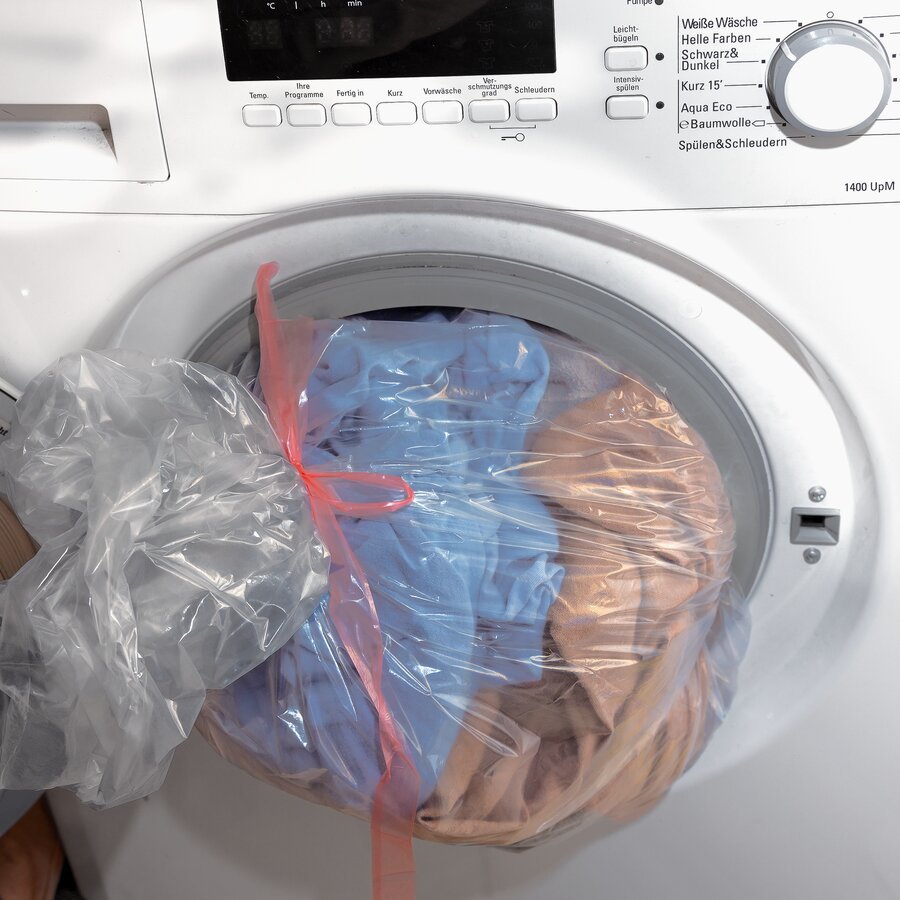 Beutel wird geschlossen mit Inhalt in die Wschetrommel gegeben